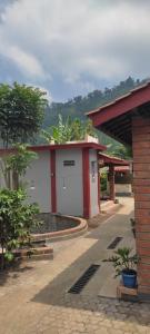 a white and red building with a courtyard at KOPIKUIN bromo homestay in Probolinggo