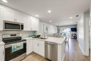 a kitchen with white cabinets and a stainless steel appliance at Laptop-Friendly Key Largo Condo with Pool View! in Key Largo