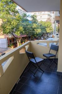 twee stoelen op een balkon met bomen op de achtergrond bij Apartamento en Rodadero in Santa Marta