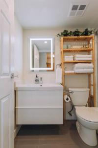 uma casa de banho com um WC, um lavatório e um espelho. em Modern Condo in the Heart of DT Overlooking City em Vancouver
