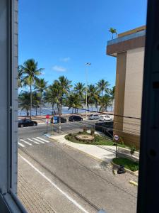 vistas a una calle con palmeras y a un edificio en Flat Beira mar de João Pessoa no Bairro Cabo Branco, en João Pessoa