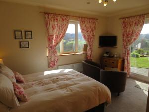 a bedroom with a bed and a large window at Heulwen Guest House in Dolgellau