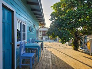 a blue house with chairs and a table on a porch at Casa Pelicano in Bocas del Toro