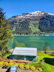 a house in front of a lake and a mountain at Ocean & Mountain View Home, near Downtown Juneau in Juneau