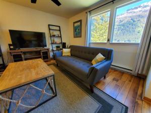 a living room with a couch and a tv at Ocean & Mountain View Home, near Downtown Juneau in Juneau
