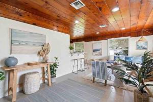 a living room with a wooden ceiling and a table and chairs at Coastal Oasis Of Lantana in Lantana