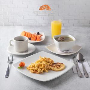 a table with two plates of food and a cup of coffee at Hotel del Llano in Villavicencio