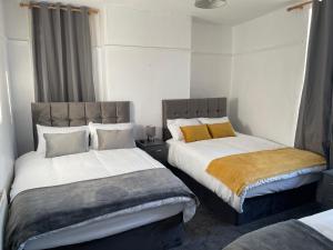a bedroom with two beds and a window at Hometel Nice Comfy Apartment Can Sleep 9 in Leicester