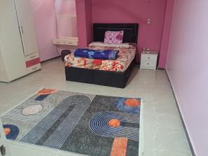 a bedroom with a bed and a rug on the floor at Sweet Home- No Egyptian in Hurghada