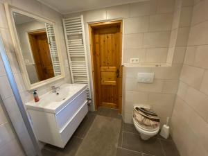 een badkamer met een wastafel en een toilet bij Ferienhaus Norddeichkieker in Norddeich