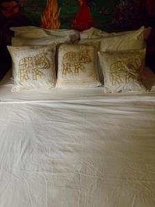 Una cama con sábanas blancas y almohadas. en Casa Grimaldo, en El Valle de Antón