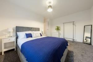 a bedroom with a large bed with a blue blanket at Modern Wolverhampton 3 bed Home in Wolverhampton