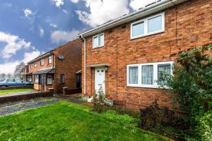 a brick house with a lawn in front of it at Modern Wolverhampton 3 bed Home in Wolverhampton