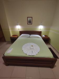 um quarto com uma cama com uma capa branca em JR HOTEL em Refineria Camiri