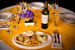 a table with a plate of food and a bottle of wine at JR HOTEL in Refineria Camiri