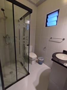a bathroom with a shower and a toilet and a sink at JR HOTEL in Refineria Camiri