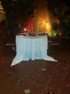 a table with a white table cloth and candles on it at JR HOTEL in Refineria Camiri