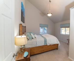 ein Schlafzimmer mit einem Bett und einem Tisch mit einer Lampe in der Unterkunft Family Getaway in Juneau Unforgettable Ocean Views in Mendenhaven