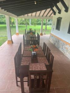 un grupo de mesas y sillas de madera en un patio en Hacienda con Piscina Privada/Aire acondicionado/Jacuzzi en Santa Fe de Antioquia