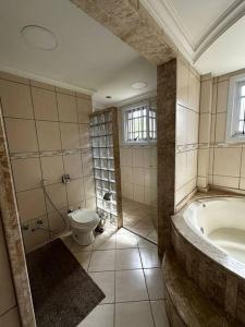 a bathroom with a tub and a toilet at apartamento em bairro nobre suíte com ar condicionado e banheira com hidromassagem in Bento Gonçalves +35 photos