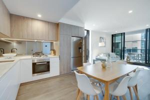 cocina y comedor con mesa y sillas en 1BR The Coterie Apartments - 1 Bedroom Deluxe Apartmen en Brisbane