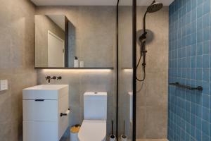 a bathroom with a toilet and a sink and a shower at 1BR The Coterie Apartments - 1 Bedroom Deluxe Apartmen in Brisbane