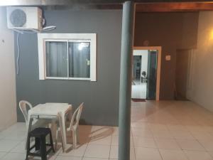 a table and chairs in a room with a window at Casa MD in Camocim