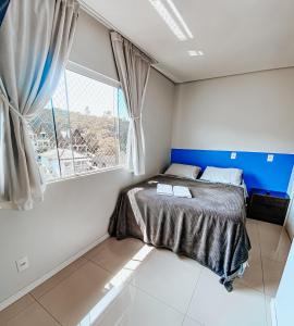 um quarto com uma cama e uma janela em Morada da Lagoinha em Florianópolis