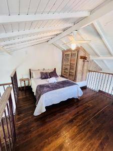 Schlafzimmer mit einem Bett und Holzboden in der Unterkunft Vila Santana Tiradentes in Tiradentes