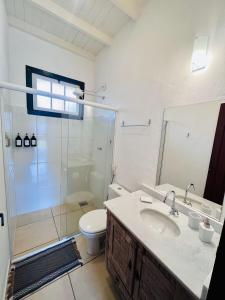 ein Bad mit einem WC, einem Waschbecken und einer Dusche in der Unterkunft Vila Santana Tiradentes in Tiradentes