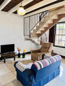 ein Wohnzimmer mit einem blauen Sofa und einem TV in der Unterkunft Vila Santana Tiradentes in Tiradentes