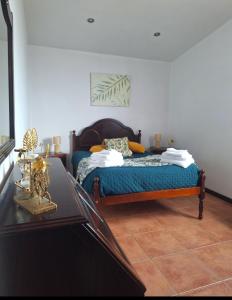 a bedroom with a bed and a table at Apartamento Bela Vista Ilha Terceira in Feteira