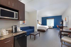 a hotel room with a kitchen and a living room at Holiday Inn Express & Suites - Cleveland Northwest, an IHG Hotel in Cleveland