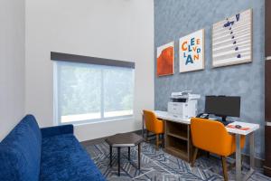 a living room with a couch and a desk with a computer at Holiday Inn Express & Suites - Cleveland Northwest by IHG in Cleveland