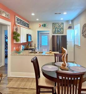 cocina con mesa y sillas y cocina con fregadero en The Poolside Bungalow en Galveston