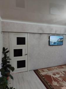 カラコルにあるErkina's - Beautiful Condo in downtownの壁にテレビが取り付けられたリビングルーム