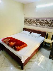 um quarto com uma cama com um cobertor vermelho em AMAN RESIDENCY em Nova Deli