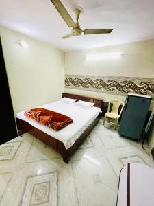 1 dormitorio con 1 cama y ventilador de techo en AMAN RESIDENCY en Nueva Delhi