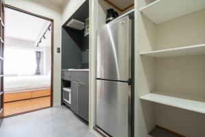 a kitchen with a stainless steel refrigerator and a bedroom at Angel Resort Yuzawa in Yuzawa