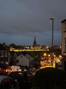 a city with cars parked on a street at night at Westland Suites - Stylish, Modern, Elegant, Central Apartments in Londonderry County Borough