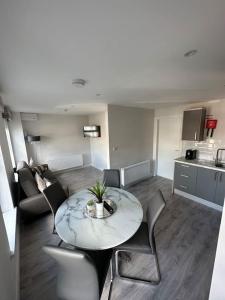 a living room with a table and chairs and a kitchen at Westland Suites - Stylish, Modern, Elegant, Central Apartments in Londonderry County Borough