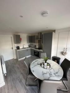 - une cuisine avec une table et des chaises dans la chambre dans l'établissement Westland Suites - Stylish, Modern, Elegant, Central Apartments, à Londonderry County Borough