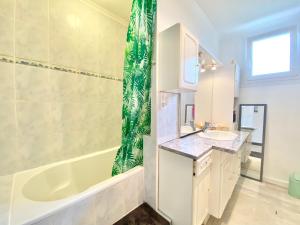 a bathroom with a tub and a sink and a shower at LA REUNION - Maison - Jardin Clos - Wifi in Ergué-Gabéric