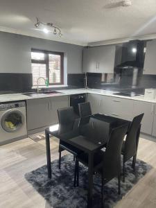 a kitchen with a black table and chairs in it at Alaya's Homes 4 bedroom house in Pitsea