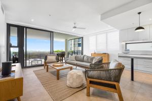 a living room with a couch and a table at Seanna Residences Bokarina Beach in Kawana Waters