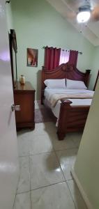 a bedroom with a bed and a dresser and a bed sidx sidx sidx sidx at Finest Accommodation 75 Blossom, The Orchards innswood St Catherine in Spanish Town