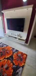 a living room with a flat screen tv and a rug at Finest Accommodation 75 Blossom, The Orchards innswood St Catherine in Spanish Town