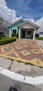 a house with a design on a brick driveway at Finest Accommodation 75 Blossom, The Orchards innswood St Catherine in Spanish Town