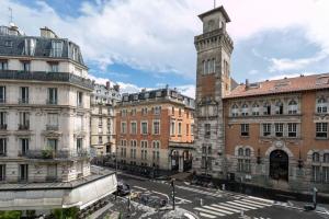 ulica miejska z budynkami i wieżą zegarową w obiekcie Amazing flat Jardin du Luxembourg w Paryżu