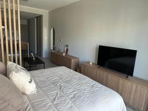 una camera con letto e TV a schermo piatto di Oasis con amenities a estrenar a Buenos Aires